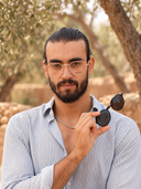 GANGO — homme en lunettes de vue, sourire discret bouche fermée, ambiance automne naturelle.